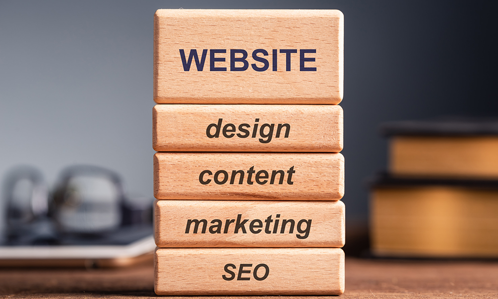 Stack wood blocks with text concept of website building or create success website on the desk